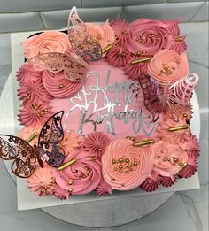 a birthday cake decorated with pink flowers and butterflies