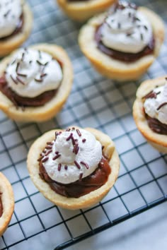 small desserts with chocolate and whipped cream are on a cooling rack