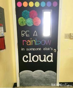 a door decorated with paper flowers and the words be a rainbow in someone else's cloud