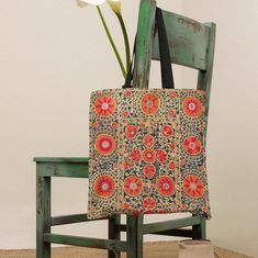 a chair with a flower in it and a tote bag on top of it