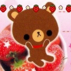 a brown teddy bear sitting on top of a strawberry covered donut