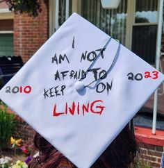 a white graduation cap with writing on it that says i am not afraid to keep on living