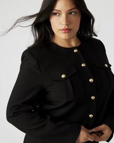 The COSETTE jacket is a sophisticated and stylish addition to any wardrobe. Crafted with twill suiting, this collarless jacket features two functional patch pockets on the chest and a button-up closure. The fully lined design with shoulder pads ensures a comfortable fit and the crest buttons add a touch of elegance with their gold accents. Collarless jacket with crest button details Shoulder pads Fully lined Two functional front pockets Length: 19.5" 76% polyester 19% viscose 5% elastane Hand wa Classic Utility Jacket With Button Cuffs For Workwear, Classic Business Blazer With Buttoned Pockets, Classic Long Sleeve Utility Jacket For Work, Formal Tailored Outerwear With Buttoned Pockets, Tailored Formal Outerwear With Buttoned Pockets, Classic Button-up Utility Jacket For Work, Chic Utility Jacket With Button Cuffs For Work, Professional Outerwear With Buttons For Work, Fitted Utility Jacket With Button Cuffs For Work