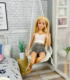 a doll sitting on a swing in a room