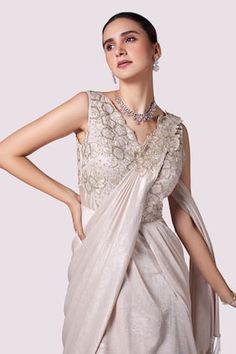 Beige layered lurex lycra gown with floral cutdana, tikki, bead and resham embellishments on the bodice featuring a saree-like pallu. - Aza Fashions Lycra Gown, Embellished Saree, Saree Gowns, Drape Gowns, Gown For Women, Saree Gown, Gown Pattern, Aza Fashion, Bodice