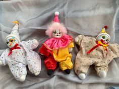 three stuffed clowns are laying on a sheet