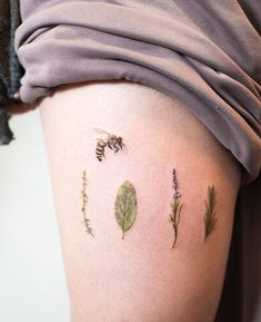 a woman's thigh with different tattoos on it