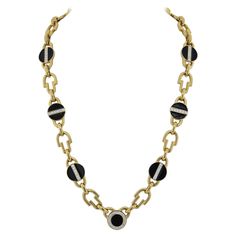 This estate David Webb 18k Yellow Gold chain exhibits the timeless allure of black enamel in jewelry. Black enamel is celebrated for its dark, moody, and bold character. It exudes confidence, mystery, and remarkable versatility in the emotions it elicits. This chain, measuring 26 inches in length, is crafted by David Webb in Platinum & 18K Yellow Gold. Its high-polish link design is adorned with striking black enameled discs, elegantly accentuated by round-cut diamonds. The smooth finish, black enamel, and diamonds create a captivating blend. The combination of yellow gold and black enamel is a harmonious balance of neutrality and boldness, making this jewelry piece effortlessly wearable with a wide range of outfits. It's a truly winning combination. Luxury Black Enamel Statement Necklace, Elegant Black Link Jewelry, Black Link Jewelry For Formal Occasions, Luxury Black Chain Necklace, Elegant Black Necklace With Cable Chain, Luxury Black Enamel Round Necklace, Modern Black Chain Necklace For Formal Occasions, Timeless Black Enamel Necklace, Modern Black Formal Chain Necklace