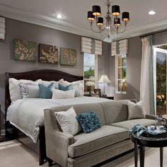 a bedroom with a large bed, couch and table in front of a sliding glass door