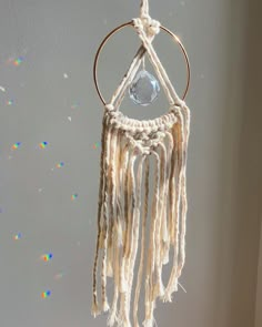 a white dream catcher hanging from a wall