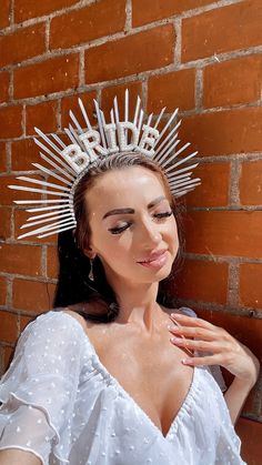 a woman wearing a white dress and a tiara with spikes on it's head