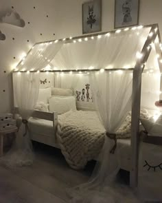 a bed with white sheets and lights on it