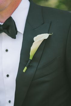 a man in a tuxedo with a white flower on it's lapel