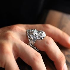 This incredible tyrannosaurus rex head ring is made in sterling silver. We have carefully made the teeth and skin details to create a more realistic effect. Dimensions: 21mm X 21mm X 23mm. These measurements may vary depending on the size of the ring. Other sizes available only on request. If you have any questions about your ring size, do not hesitate to contact us. Dinosaur Rings, Dinosaur Stuff, Dinosaur Ring, Dinosaur Jewelry, Dinosaur Head, Masc Outfits, Skin Details, The Teeth, Biker Rings