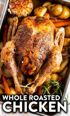 whole roasted chicken in a roasting pan with potatoes and carrots