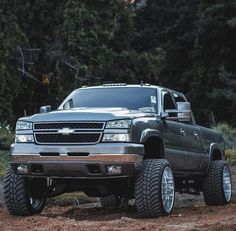 a silver truck parked on top of a dirt field