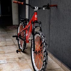 a red bicycle parked in front of a building with black and white designs on it