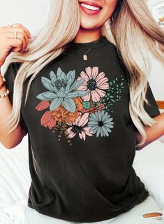 Elevate your wardrobe with our charming Women's Floral Print T-Shirt, blooming with elegance and style. Embrace the beauty of nature with a delicate floral pattern that adds a touch of femininity to any outfit. Crafted from soft, breathable fabric, this tee ensures comfort throughout the day. Perfect for casual weekends, brunch dates, or relaxing at home, it pairs effortlessly with jeans, shorts, or skirts. Available in a range of sizes and vibrant floral designs, it's a versatile staple that co Trendy Multicolor Floral Print T-shirt, Trendy Floral Print Crew Neck T-shirt, Spring Floral Print Graphic Tee, Multicolor Floral Print T-shirt For Spring, Spring Multicolor Floral Print T-shirt, Relaxed Fit Floral Print T-shirt For Spring, Spring Plants Print Short Sleeve T-shirt, Spring Black T-shirt With Floral Print, Trendy Floral Print Short Sleeve T-shirt