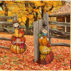 two pumpkins are sitting on top of each other in front of a wooden fence