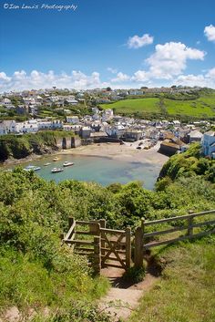 a scenic view of a small town and the sea with boats on it's shore