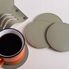 a cup of coffee sits next to some coasters