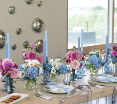 the table is set with blue and pink flowers