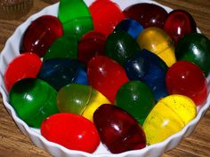 a bowl filled with gummy bears on top of a wooden table