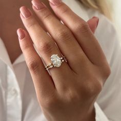 a woman's hand with a diamond ring on her left and an engagement ring on her right