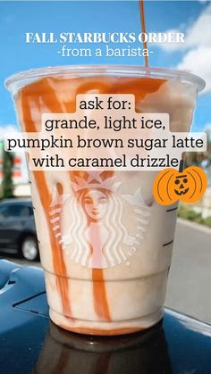 an orange and white drink sitting on top of a table next to a black car