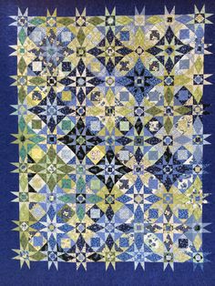 a blue and yellow quilt with many different designs on the front, one is made out of