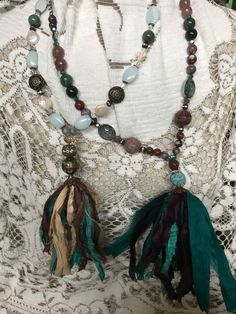 This is a choice of multicolored tassel necklace is made of silk combined with earthtones beautiful jewels and rhinestones. One combines turquoise cream and brown with the earth tones and the other one is a combination of hunter green burgundy and teal.Both are very unique and lovely and definitely make a statement! No returns. Shipped to Connell US only. The listing is for one necklace Bohemian Turquoise Tassel Jewelry, Artisan Brown Jewelry With Tassels, Bohemian Turquoise Necklaces With Tassels, Bohemian Adjustable Tassel Necklace With Fringe, Bohemian Brown Tassel Jewelry, Bohemian Long Tassel Necklace With Fringe, Bohemian Long Fringe Tassel Necklace, Bohemian Long Tassel Fringe Necklace, Brown Bohemian Tassel Necklace