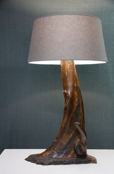 a lamp that is on top of a table with a wooden base and fabric shade