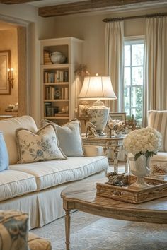 a living room filled with lots of furniture and flowers on top of a coffee table