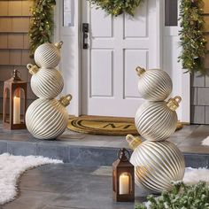 two white christmas balls sitting on the front steps