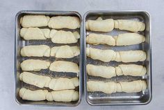 two metal pans filled with food sitting on top of a gray counter next to each other