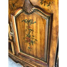 an old wooden armoire with flowers painted on it