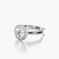 a diamond ring on a white surface with the center stone surrounded by small round diamonds