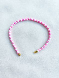 Handcrafted white and pink beaded anklet/bracelet. Made using small colourful round glass beads and finished with a gold-plated barrel clasp closure. Pair it with our matching Necklace.  * Weight: 7g   * Width: 5mm/2mm  * Made in UK  * Code: 111AWPS The very best in unique, handmade pieces from BAM-BAM, our anklets and bracelets make great accessories for the beach, festival or club. These small beads have a dainty appearance and can take your best looks from day to night. Adjustable Pink Single Strand Beaded Bracelets, Adjustable Pink Single Strand Beaded Bracelet, Adjustable Single Strand Pink Beaded Bracelet, Adjustable Pink Anklet With Colorful Beads, Pink Spacer Beads For Beach, Pink Heishi Beads For Beach, Pink Beaded Bracelet With Heart And Heishi Beads, Pink Heishi Beaded Bracelet With Heart Beads, Adjustable Pink Heishi Beads