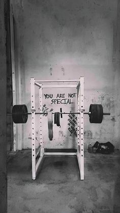 a black and white photo of a bench with a barbell on it that says, you are not special