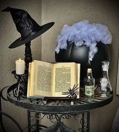 an open book sitting on top of a table next to a witch's hat