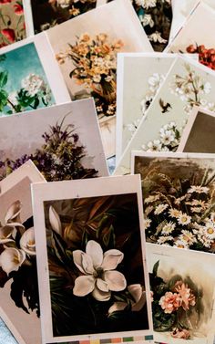 a bunch of cards with flowers on them sitting next to each other in a pile