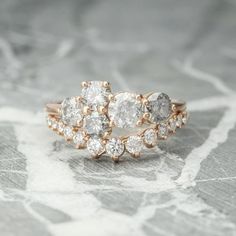 a close up of a ring with diamonds on the top and bottom, sitting on a marble surface