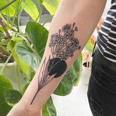 a woman's arm with a flower tattoo on the left side of her arm