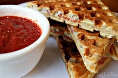 two waffles stacked on top of each other next to a bowl of salsa