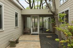 an outside view of a house with a bench and trees