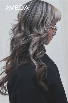 @beautybyxo.ili says, "Trust the process if you want to go light"—and we are STUNNED by these gorgeous results. Silver highlights on dark hair create an edgy look with a dazzling air of mystery. Tap to try this Aveda Color combo at your next salon appointment. #AvedaArtist #AvedaColor #SilverHair #SilverHighlight #ChunkyHighlights #SilverHighlightsDarkHair Chunky Silver Highlights, Silver Highlights On Dark Hair, Highlights On Dark Hair, Chunky Highlights, Silver Highlights