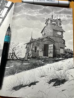 a drawing of a house in the snow with a pen and marker next to it