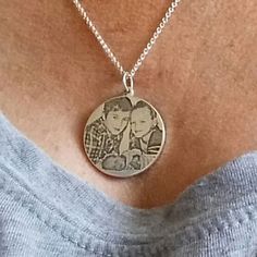 a woman wearing a necklace with two pictures on it