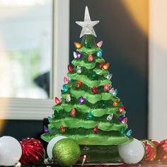 a green christmas tree sitting on top of a table