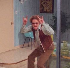 a young man riding a skateboard down the side of a stair case in a living room